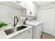 Laundry room with white cabinets, quartz countertops, and new washer/dryer at 2126 Larchwood Ct, Trinity, FL 34655