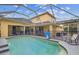 Screened pool area with patio furniture and basketball hoop at 2126 Larchwood Ct, Trinity, FL 34655