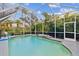 Relaxing screened pool area with waterfall feature and surrounding foliage at 2126 Larchwood Ct, Trinity, FL 34655