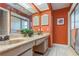 Bathroom with double vanity, tiled floor, and orange walls at 2241 Heron Circle, Clearwater, FL 33762