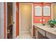 Bathroom with double vanity, toilet, and orange walls at 2241 Heron Circle, Clearwater, FL 33762