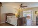 Main bedroom with wood sleigh bed, ceiling fan, and access to patio at 2241 Heron Circle, Clearwater, FL 33762