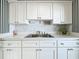 White kitchen with stainless steel appliances and black and white striped wallpaper at 229 Lime S Cir, Dunedin, FL 34698