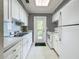 White kitchen with stainless steel appliances and black and white striped wallpaper at 229 Lime S Cir, Dunedin, FL 34698