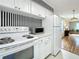 White kitchen with stainless steel appliances and a view into the dining area at 229 Lime S Cir, Dunedin, FL 34698