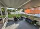 Relaxing screened porch with wicker furniture, overlooking the backyard at 25237 Seven Rivers Cir, Land O Lakes, FL 34639