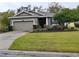 One-story house with gray siding, two-car garage, and landscaped lawn at 2815 Holly Bluff Ct, Plant City, FL 33566