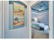 Hallway with beach-themed art leading to a bedroom at 302 Latitude Pl, Apollo Beach, FL 33572