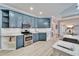 Bright kitchen with blue cabinets, gas range, and white backsplash at 302 Latitude Pl, Apollo Beach, FL 33572