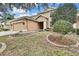 Two-story house exterior with tan siding, attached two-car garage and landscaped yard at 4381 Caliquen Dr, Brooksville, FL 34604