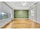 Bright living room featuring hardwood floors and an accent wall at 4381 Caliquen Dr, Brooksville, FL 34604