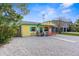 Quaint yellow cottage with gravel driveway and carport at 5421 Circle Dr, Weeki Wachee, FL 34607