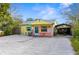 Quaint yellow cottage with gravel driveway and carport at 5421 Circle Dr, Weeki Wachee, FL 34607