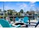 Waterfront fire pit with teal Adirondack chairs and a table at 5421 Circle Dr, Weeki Wachee, FL 34607