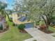 House with gray garage door, surrounded by lush greenery at 5608 Rockfield Loop, Valrico, FL 33596