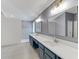 Modern bathroom with double vanity, blue cabinets, and quartz countertop at 5608 Rockfield Loop, Valrico, FL 33596