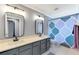 Updated bathroom with double vanity, modern fixtures, and patterned shower curtain at 5608 Rockfield Loop, Valrico, FL 33596