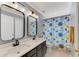 Shared bathroom with double vanity and a floral shower curtain at 5608 Rockfield Loop, Valrico, FL 33596