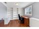 Home office with built-in shelving, wood floors, and a large desk at 5608 Rockfield Loop, Valrico, FL 33596