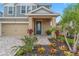 Two-story house with gray siding, tan accents, and a landscaped front yard at 5636 Silver Sun Dr, Apollo Beach, FL 33572