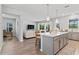 Open concept kitchen flows into living room, featuring an island and breakfast bar at 5636 Silver Sun Dr, Apollo Beach, FL 33572