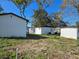 View of the backyard, showcasing two white buildings and a partially cleared lot at 6413 N 48Th St, Tampa, FL 33610