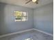 Well-lit bedroom featuring a window and ceiling fan at 6413 N 48Th St, Tampa, FL 33610