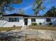 Newly renovated home with a modern exterior and landscaped lawn at 6413 N 48Th St, Tampa, FL 33610