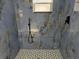 Modern shower with geometric patterned tile floor at 6413 N 48Th St, Tampa, FL 33610