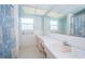 Bright bathroom featuring a double sink vanity, white tile, and decorative blue and white shower curtain at 6909 13Th N Ave, St Petersburg, FL 33710