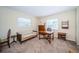 Home office setup with neutral carpet, a small couch, and a wooden desk by the windows at 6909 13Th N Ave, St Petersburg, FL 33710