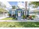 Charming bungalow with a freshly painted blue exterior, landscaping, and a white picket fence at 8907 N Boulevard, Tampa, FL 33604