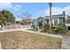 House's exterior showcases a blue facade, well-maintained lawn, and a white fence at 8907 N Boulevard, Tampa, FL 33604