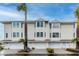 Three-unit building, light beige siding, attached garages, and landscaping at 9341 Blind Pass Rd, St Pete Beach, FL 33706