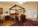 Main bedroom with four-poster bed and views of the backyard at 9341 Blind Pass Rd, St Pete Beach, FL 33706