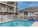 Community pool with surrounding patio and building view at 9341 Blind Pass Rd, St Pete Beach, FL 33706