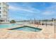 Resort-style pool and spa with adjacent building and waterfront views at 9341 Blind Pass Rd, St Pete Beach, FL 33706