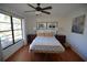 Cozy bedroom with hardwood floors, a ceiling fan, and a large window at 10303 Chadbourne Dr, Tampa, FL 33624