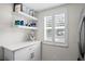 White kitchen with floating shelves and window at 11511 113Th St # 12C, Seminole, FL 33778