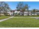 Inviting two-story condo with balconies, mature trees, and a well-maintained green lawn at 130 Lakeview Way # 130, Oldsmar, FL 34677