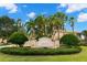 Welcoming entrance to Toscana community featuring lush landscaping, mature palms, and an elegant sign at 1354 Emerald Dunes Dr, Sun City Center, FL 33573