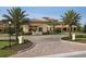 Inviting community entrance with palm trees and brick pavers at 1354 Emerald Dunes Dr, Sun City Center, FL 33573