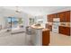 Kitchen blends with the living area and offers lake views, bar seating, and modern white appliances at 1354 Emerald Dunes Dr, Sun City Center, FL 33573