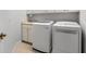 Bright laundry room features modern washer and dryer, cabinets, and a utility sink for added convenience at 1354 Emerald Dunes Dr, Sun City Center, FL 33573