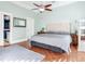 Serene bedroom with a tufted headboard, ceiling fan, and hardwood floors at 1503 Limona Rd, Brandon, FL 33510
