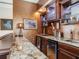 Home wet bar with granite countertop and custom cabinetry at 1503 Limona Rd, Brandon, FL 33510