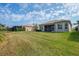 Expansive backyard with lush green lawn and a view of the screened lanai at 16127 Cape Coral Dr, Wimauma, FL 33598