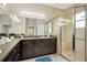 Bright bathroom with large mirror, dual sinks, and a modern glass-enclosed shower at 16127 Cape Coral Dr, Wimauma, FL 33598