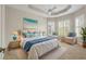 Relaxing bedroom with tray ceiling, coastal decor, and natural light from shuttered windows at 16127 Cape Coral Dr, Wimauma, FL 33598