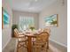 Dining room with a wooden table, seating for six, plantation shutters, and coastal-themed wall art at 16127 Cape Coral Dr, Wimauma, FL 33598